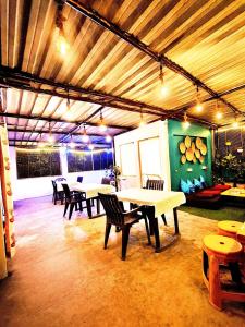 eine Gruppe von Tischen und Stühlen in einem Raum in der Unterkunft Hidden Monkey Hostel, Chet Singh Ghat, Varanasi in Varanasi