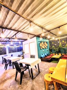 ein Raum mit Tischen und Stühlen in einem Gebäude in der Unterkunft Hidden Monkey Hostel, Chet Singh Ghat, Varanasi in Varanasi