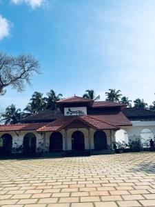 IrimbranallūrMayanadhi Resort的一座带瓷砖屋顶和庭院的建筑