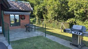 a barbecue grill and a table in a backyard at Lago Maggiore Escape - suite con idromassaggio esterno in Nebbiuno
