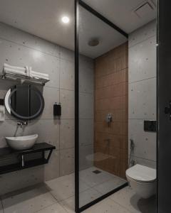 a bathroom with a shower and a toilet and a sink at Mayanadhi Resort in Irimbranallūr