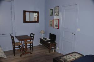 a room with a desk and a table with a computer at Vaste chambre au centre du bourg in Saulieu