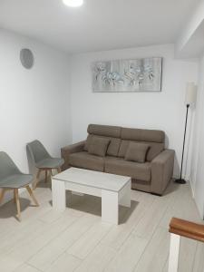 ein Wohnzimmer mit einer Couch und einem Tisch und Stühlen in der Unterkunft Apt isabel in Ardales