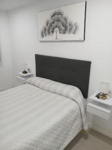 ein Schlafzimmer mit einem Bett mit einem Baum an der Wand in der Unterkunft Apt isabel in Ardales