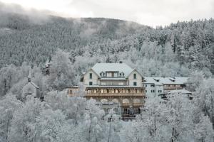 ein großes Haus mitten in einem schneebedeckten Wald in der Unterkunft Gasthof Kohlern 1130 m in Bozen