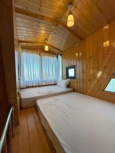 duas camas em um quarto de madeira com janela em Muskan Mount View Retreat, Mukteshwar em Mukteswar