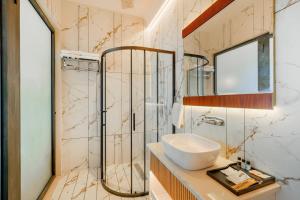 a bathroom with a sink and a glass shower at Hotel Marrion in Amritsar +36 photos