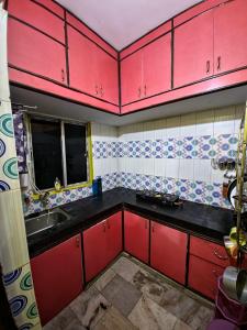 a kitchen with red cabinets and a sink at mahitra beautiful homestay in Patna