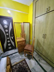 a bedroom with a chair and a dresser and a mirror at mahitra beautiful homestay in Patna +6 photos