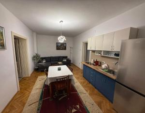 a kitchen and living room with a table and a refrigerator at Casa Victoria in Făgăraş
