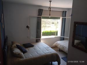 a small room with a bed and a window at Hostal prados abiertos in La Parra