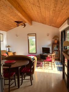 a living room with a wooden ceiling and a table at Gîte Soye in Eauze