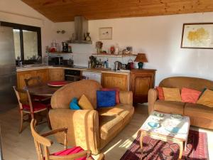 a living room with two couches and a table at Gîte Soye in Eauze