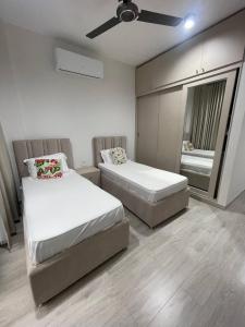 Un dormitorio con dos camas y un ventilador de techo. en Luxurious 3BR Apartments at Salalah, en Salalah
