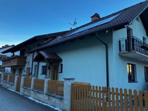 una casa blanca con una valla de madera delante de ella en Ferienwohnung Familie Hernaus, en Etmissl