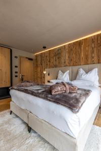 a bedroom with a large white bed with wooden walls at Paradise Lodge in Livigno