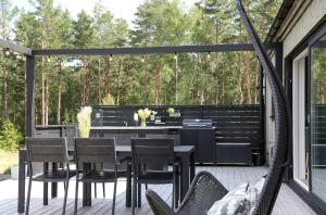 埃克舍Lake Cottage With Sunsets Over Försjön的露台上有一张桌子和几把椅子