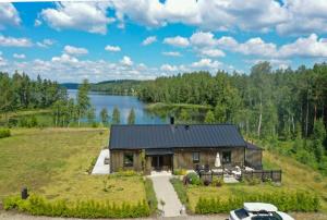 埃克舍Lake Cottage With Sunsets Over Försjön的山坡上有一栋房子，旁边有个湖。