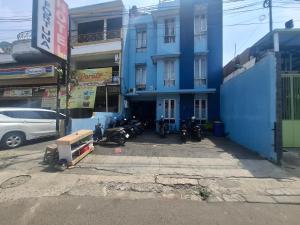 Un edificio azul con motocicletas estacionadas frente a él. en Tamastu Hotel Fortuna Jatiwaringin, en Pangkalan