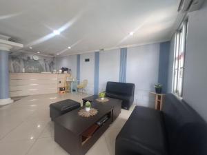 una sala de estar con un sofá y una mesa en Tamastu Hotel Fortuna Jatiwaringin, en Pangkalan