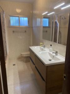 un bagno con lavandino, WC e specchio di Villa CASTILLA a Cambrils