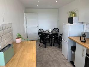 a kitchen with a table with chairs and a refrigerator at Cartref 2 Double Bed Apartment Nebo Dogs Welcome in Amlwch