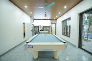 Una mesa de billar en una habitación con ventilador de techo. en Tràng An Riverbank Homestay, en Nguyên Ngoại
