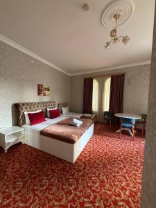 a hotel room with a large bed and a table at Sarp Hotel in Baku
