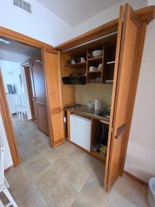 Is Molas Is Molas Domus Michela的一间小厨房,配有木制橱柜和瓷砖地板