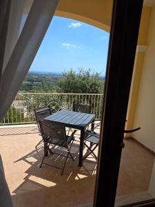 Una mesa y sillas en un balcón con vista. en Is Molas Domus Michela, en Is Molas 
