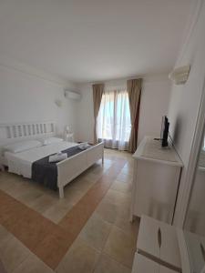 Un dormitorio con una cama y un televisor. en Is Molas Domus Michela, en Is Molas 