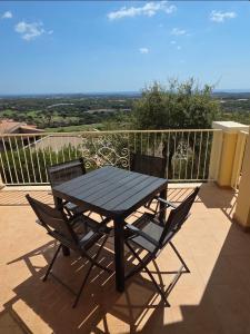 una mesa negra y 2 sillas en el balcón en Is Molas Domus Michela, en Is Molas 