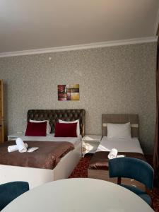 a hotel room with two beds and a table at Sarp Hotel in Baku