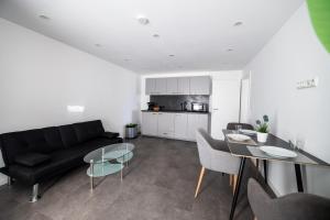 ein Wohnzimmer mit einer schwarzen Couch und einem Tisch in der Unterkunft W&P Living Wohnung mit Ausblick - Parkplatz in Biberbach + 4 Fotos