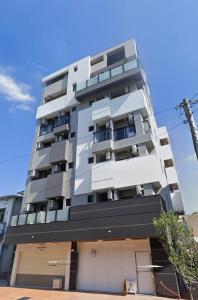 ein hohes weißes Wohnhaus mit Fenstern in der Unterkunft 東印象 in Hsin-kuang