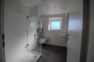 ein weißes Bad mit einem WC und einem Fenster in der Unterkunft W&P Living Wohnung mit Ausblick - Parkplatz in Biberbach