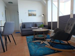 un soggiorno con un divano, un tavolo e delle sedie di Haus Meeresblick WM510 a Kühlungsborn