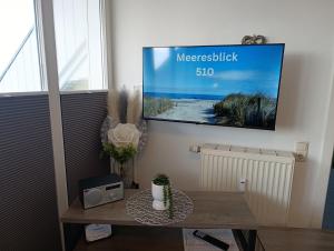 una TV appesa a una parete in un soggiorno di Haus Meeresblick WM510 a Kühlungsborn Altre 10 foto