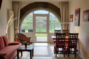 a living room with a table and chairs and a large window at Strandhof Möhnesee in Möhnesee