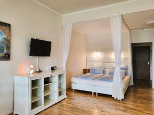 a bedroom with a white bed with a canopy at Strandhof Möhnesee in Möhnesee