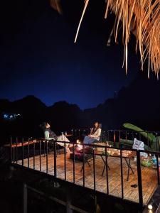 two people sitting in chairs on the beach at night at บ้านสวนผาหมี in Ban Nong Chaeng