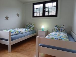 a bedroom with two beds and a window at ZusammenZeit in Schleiden - inklusive Sauna, Garage, großer Terrasse und 3 Schlafzimmer - ideal für Familien und Freunde - Hunde freundlich in Schleiden +43 photos