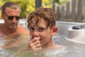 拉迪斯LAUDEGGHOF Ladis的一个男人在浴缸里，一个男孩正伸着舌头