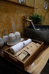ein Badezimmer mit einem Holztablett mit Handtüchern und einem Waschbecken in der Unterkunft Tam Coc Holiday Retreat in Ninh Bình