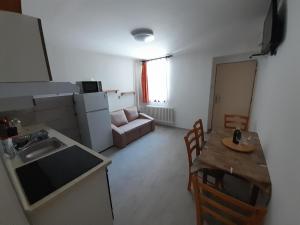 a kitchen and dining room with a table and a kitchen and a table and chairs at Apartmán 254 b in Janske Lazne