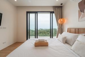 a bedroom with a large white bed with a large window at Staylar Sunrise Villas - Chaweng Noi, Koh Samui in Amphoe Koh Samui +220 photos