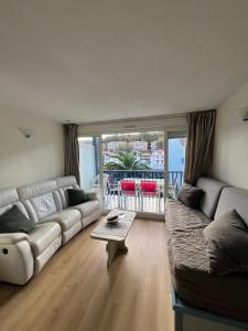 un soggiorno con un divano e un tavolo di appartement Xiberoa Socoa a Urrugne Altre 3 foto