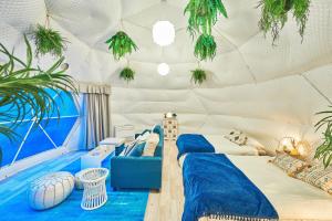 a room with two beds in a tent with plants at リバーサイドグランピングNuts in Higashiomi