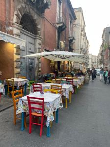 a row of tables and chairs with umbrellas on a street at Sogni al Duomo in Catania