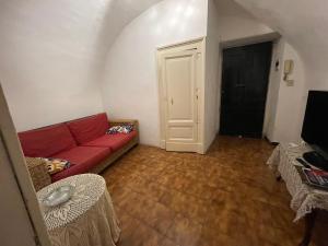a living room with a red couch and wooden floors at Sogni al Duomo in Catania
